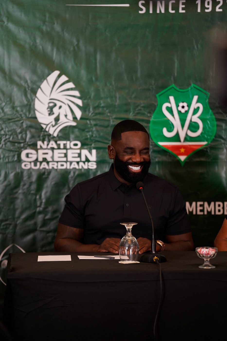 Brian Tevreden lacht tijdens een persconferentie van Natio